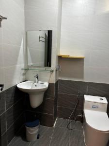 Un baño con lavabo, inodoro y espejo. en Little House Homestay Đà Lạt, Trung Tâm Thành Phố, en Da Lat