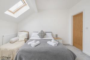 a bedroom with a bed with two towels on it at Stylish 3 bedroom house with garage in Frome