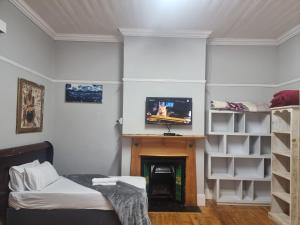 a living room with a fireplace and a tv at AIDEN'S GUEST HOUSE in Port Elizabeth