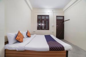 a bedroom with a bed with orange and blue pillows at Super OYO SPOT ON Hotel Aina in Rānīkhet