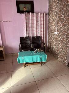 a living room with a table and two chairs at Badriniwas homestays in Almora