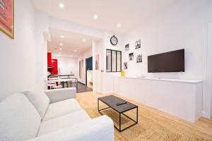 un soggiorno con divano bianco e TV di Exceptionnel à Montmartre a Parigi