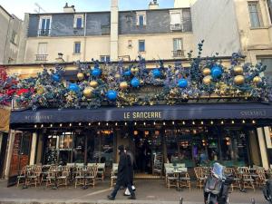 Ein Mann läuft vor einem Laden mit Weihnachtsdekorationen. in der Unterkunft Exceptionnel à Montmartre in Paris