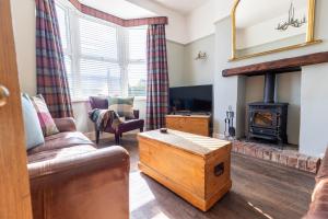 a living room with a couch and a fireplace at Driftwood Cottage in Seahouses