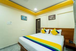 a bedroom with a bed with a rainbow blanket at Itsy By Treebo - Anand Executive, Near Amanora in Pune