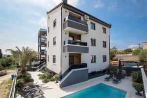 uma vista exterior de um edifício com piscina em Apartments Sara II em Ližnjan
