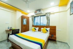 a bedroom with a bed with a colorful blanket at Itsy By Treebo - Anand Executive, Near Amanora in Pune