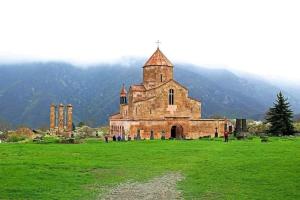 an old church in a field of green grass at Tsatʼer Guest House in Tsatʼer