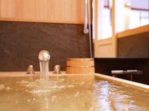 bañera llena de agua con grifo en NIPPONIA HOTEL 伊賀上野 城下町, en Iga