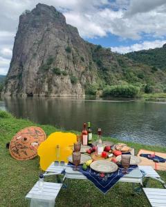 una mesa de picnic con comida y botellas de vino junto a un lago en Tsatʼer Guest House, en Tsatʼer