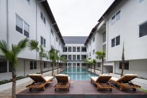 obraz dziedzińca hotelu z leżakami i basenem w obiekcie Cove Nawaprita w Dżakarcie