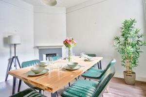 uma sala de jantar com uma mesa de madeira e cadeiras verdes em Spacious 3 Bedroom House City Centre Millers Point 2 E-Bikes Included em Sydney