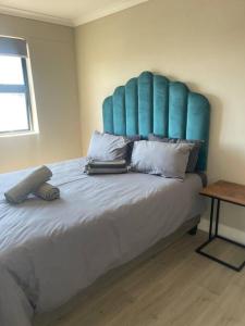 a bedroom with a large bed with a blue headboard at 74 Chapel Towers - City Centre in Cape Town