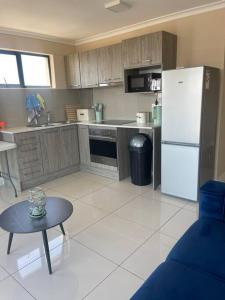 a kitchen with a white refrigerator and a table at 74 Chapel Towers - City Centre in Cape Town
