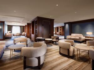 a lobby with chairs and tables and a couch at Nagoya Kanko Hotel in Nagoya