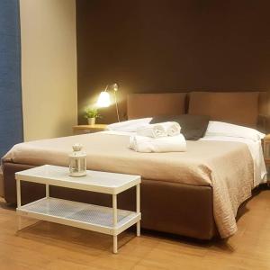 Un dormitorio con una cama con una mesa al lado. en XX Miglia rooms & apartments, en Catania