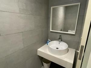 uma casa de banho com um lavatório branco e um espelho. em Anggun Arte Mont Kiara em Kuala Lumpur