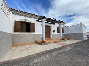 a white house with a porch and a driveway at El Olivar Corralejo Sun & Beach in Corralejo