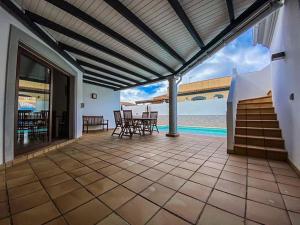 a patio with tables and chairs and a view of the ocean at El Olivar Corralejo Sun & Beach in Corralejo