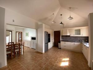 a kitchen with white cabinets and a table and chairs at El Olivar Corralejo Sun & Beach in Corralejo