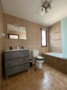 a bathroom with a sink and a toilet and a bath tub at El Olivar Corralejo Sun & Beach in Corralejo +13 photos