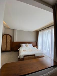 - une chambre avec un grand lit et une fenêtre dans l'établissement Cuan House Ubud, à Ubud