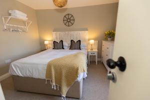 a bedroom with a bed and a dresser with two pillows at Rose Cottage by Coast & Country Stays in Beadnell