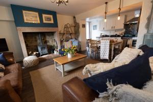 a living room with a couch and a fireplace at Rose Cottage by Coast & Country Stays in Beadnell