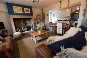 a living room with a couch and a fireplace at Rose Cottage in Beadnell