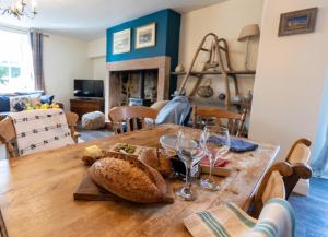 a wooden table with bread and wine glasses on it at Rose Cottage by Coast & Country Stays in Beadnell +40 photos