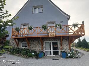 a house with a balcony on top of it at Sowi Dom - Jugów in Jugów