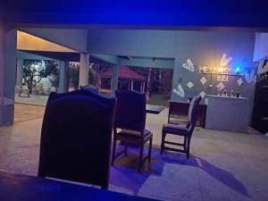 een groep stoelen voor een gebouw bij Etna Apartments in Takoradi