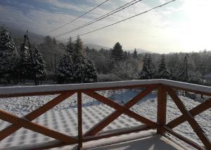a wooden fence with snow on the ground at Sowi Dom - Jugów in Jugów
