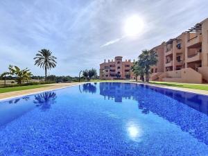 a large blue swimming pool next to some buildings at La Serena Apartment - 3410 in Los Alcázares