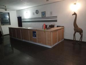 a reception desk with a giraffe statue in a room at Etna Apartments in Takoradi