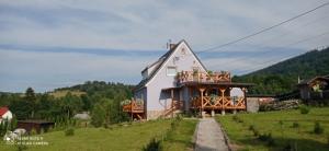 a house with a balcony on the side of it at Sowi Dom - Jugów in Jugów
