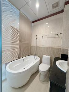 een badkamer met een bad, een toilet en een wastafel bij Phúc Đạt Hotel in Vung Tau