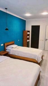 a bedroom with two beds and a blue wall at cottage 3-029 in Bakuriani