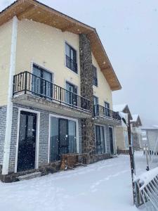 un edificio con la neve sul terreno di fronte ad esso di cottage 3-029 a Bakuriani