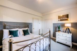 1 dormitorio con cama, lámpara y cómoda en Garden Flat West Kincaple House, en St Andrews
