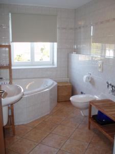 uma casa de banho com uma banheira, um WC e um lavatório. em Haus Carmen auf Usedom Nr.6 em Ziemitz