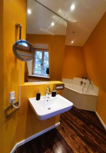 ein Badezimmer mit einem Waschbecken, einer Badewanne und einem Spiegel in der Unterkunft Schöne Mindeltal Wohnung - Legoland - Skylinepark in Thannhausen