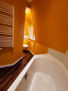 eine große Badewanne im Badezimmer mit orangefarbenen Wänden in der Unterkunft Schöne Mindeltal Wohnung - Legoland - Skylinepark in Thannhausen