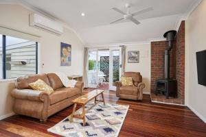 a living room with a couch and a fireplace at Moonya Avocado Farm Cottage - with early check-in in Mount Tamborine