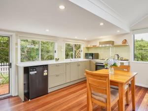 uma cozinha com uma mesa de madeira e um piso de madeira em Moonya Avocado Farm Cottage - with early check-in em Mount Tamborine