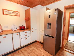 a kitchen with a stainless steel refrigerator and white cabinets at Ar Dachaigh in Paible