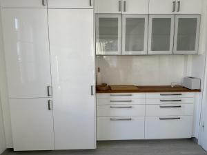 cocina blanca con armarios blancos y encimera en Blum Ferienwohnung, en Constanza