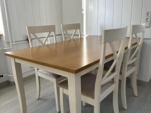 una mesa de madera con 4 sillas alrededor en Blum Ferienwohnung, en Constanza