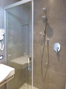 カットーリカにあるHOTEL D'ANNUNZIOのバスルーム(ガラスドア付きのシャワー付)