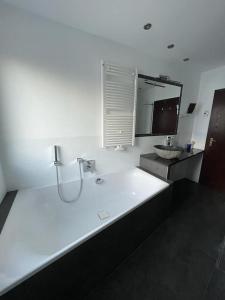 a bathroom with a large bath tub and a mirror at Near Frankfurt +32 pinball, arcade, billiard,Dart in Hattersheim +29 photos